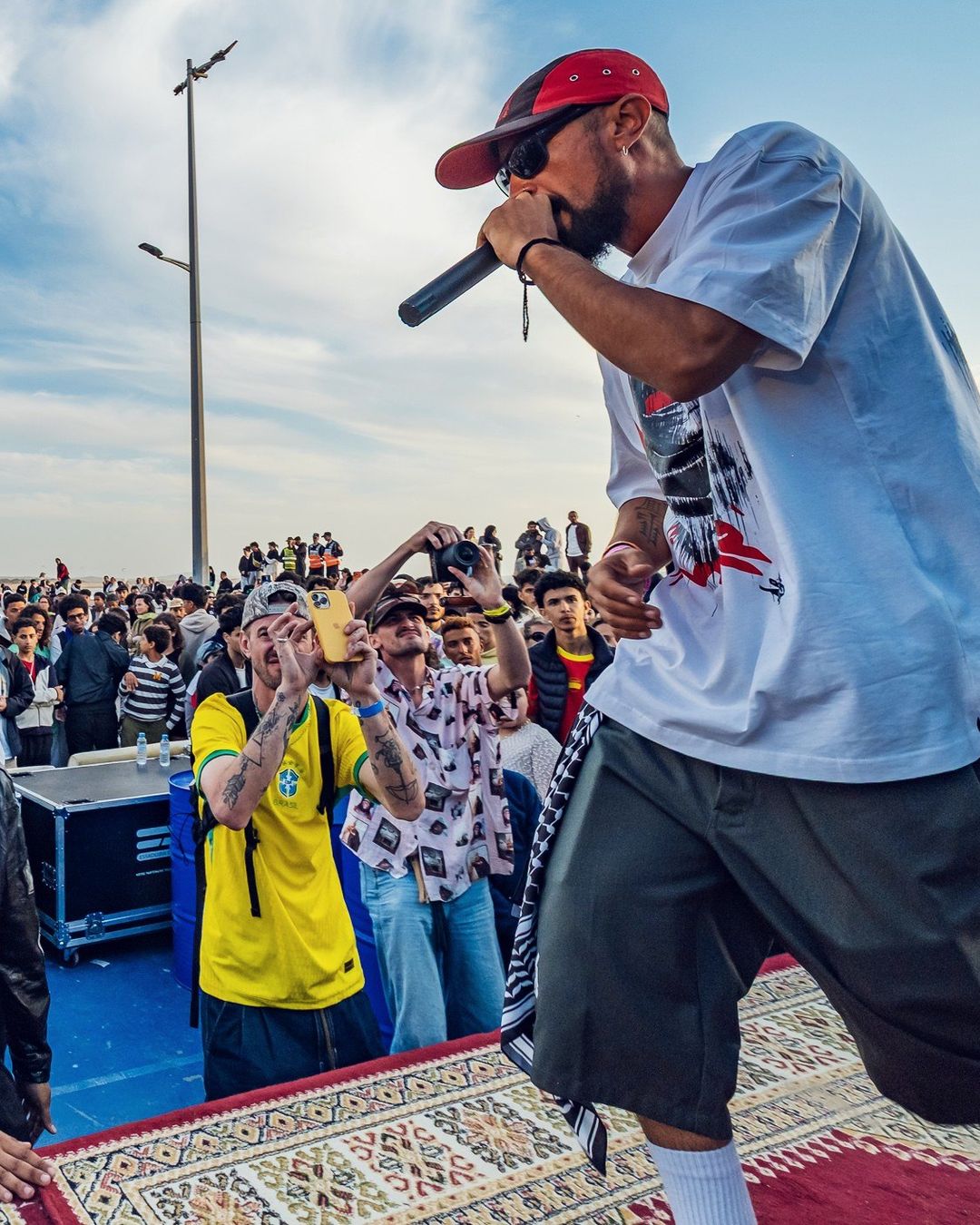 Le MC au micro face à la foule de la corniche, en 2026