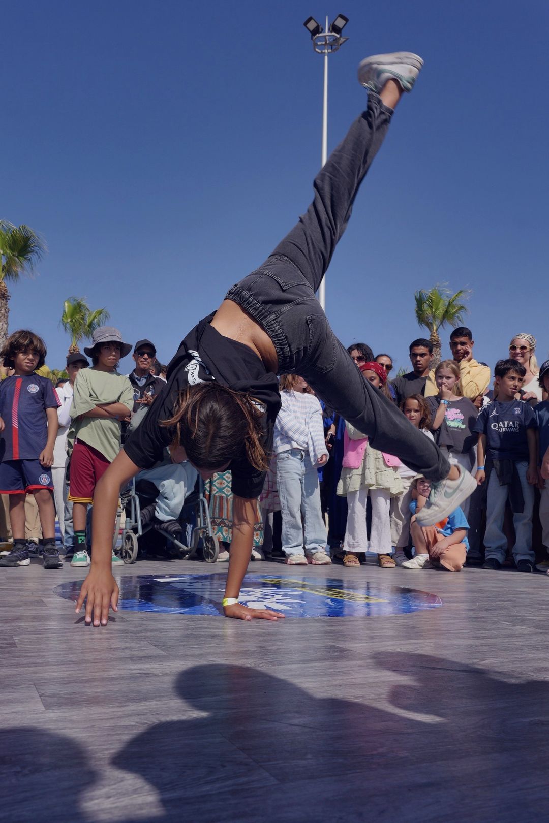 Une danseuse en appui sur une main, une jambe tendue vers le ciel